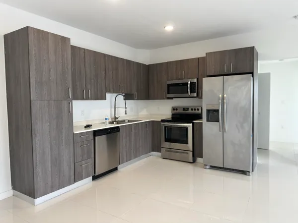a view of a kitchen with a refrigerator and a sink