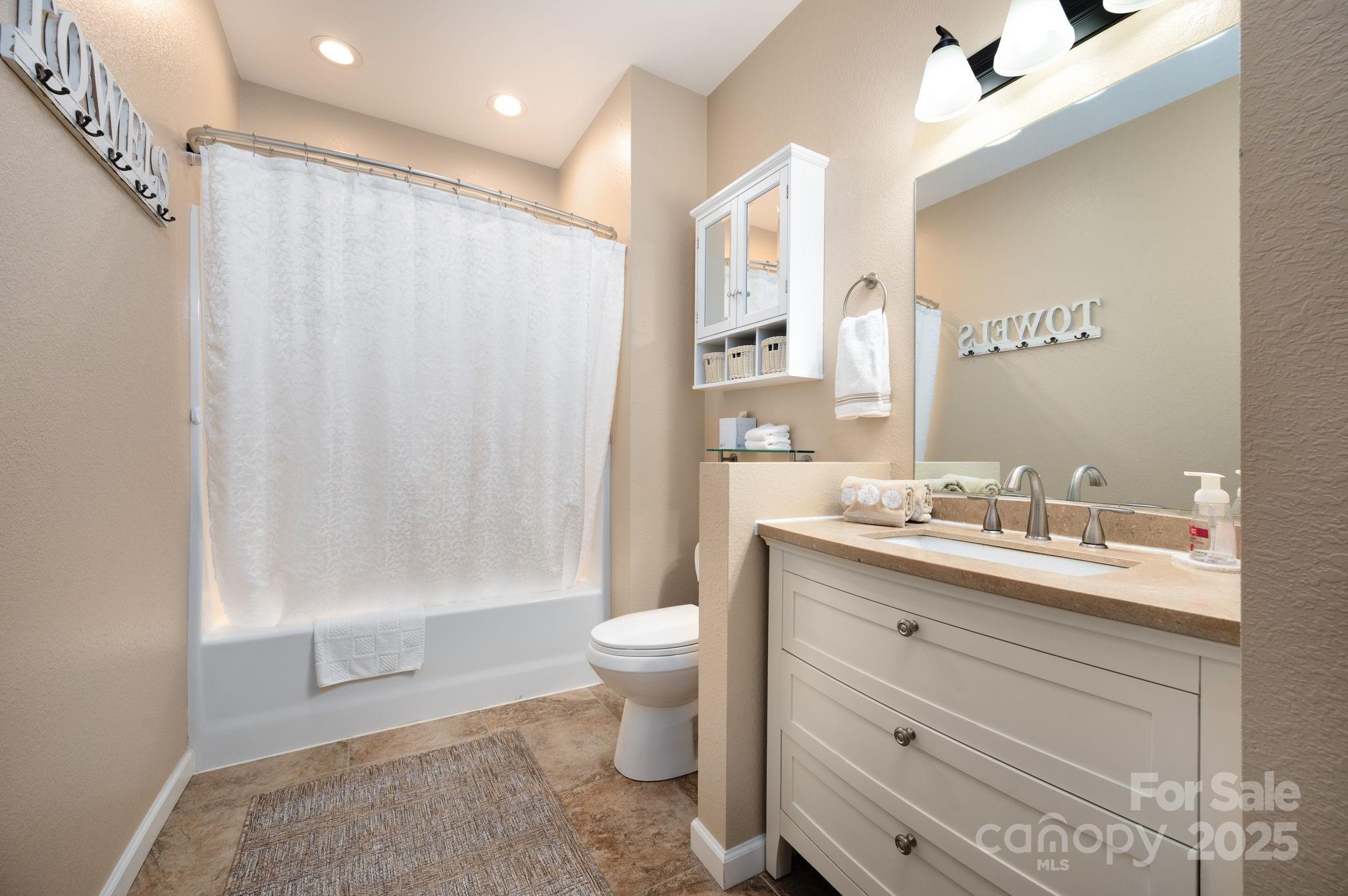 174 Diamond Point Canton, NC 28716 - Photo 26 of 30 a bathroom with a granite countertop sink a toilet a mirror and shower