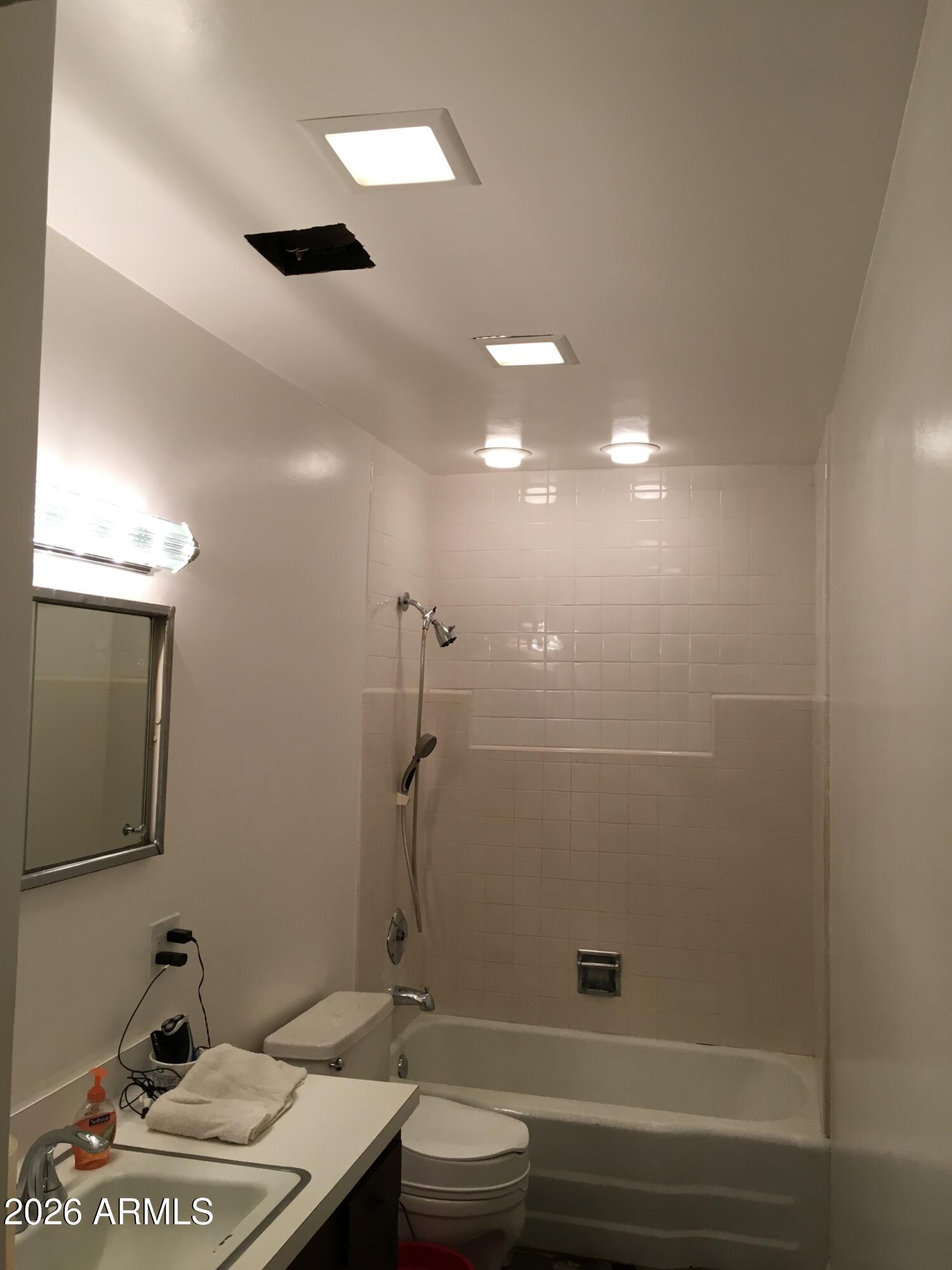 323 East Rose Lane Phoenix, AZ 85012 - Photo 18 of 20 a bathroom with a granite countertop sink a toilet and mirror