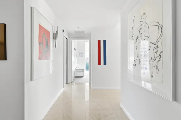 a view of a hallway with bathroom and a shower