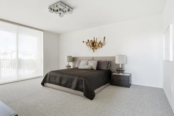 a spacious bedroom with a bed and a window