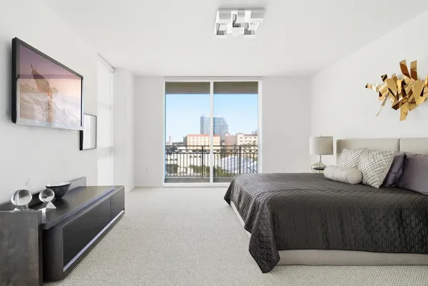 a bedroom with a bed and balcony view