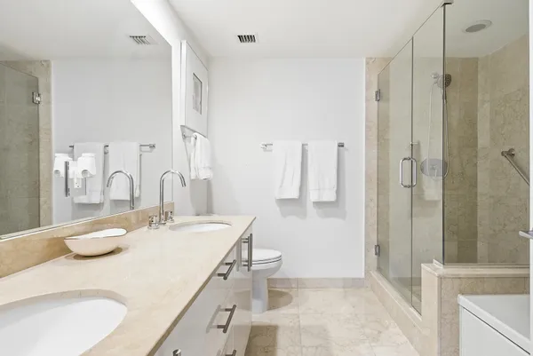 a bathroom with a double vanity sink mirror and shower