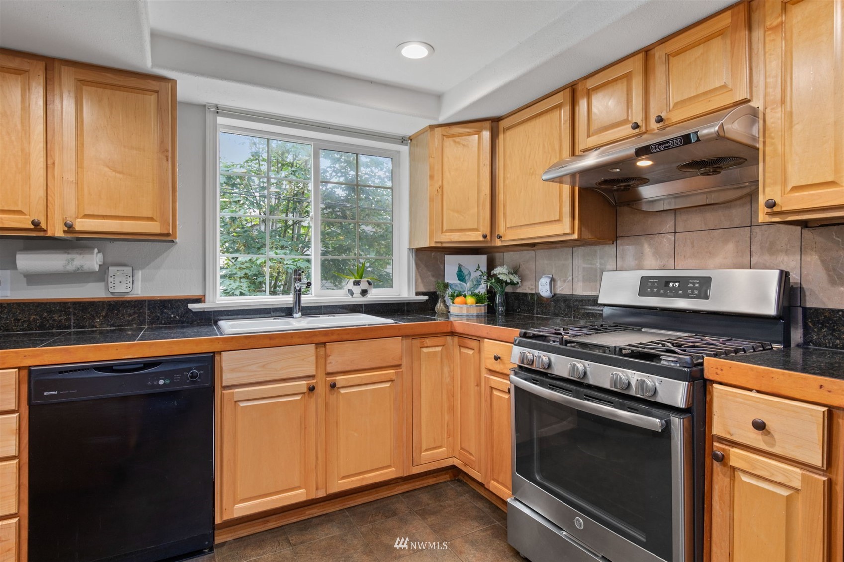 819 Duchess Road Bothell, WA 98012 - Photo 14 of 40 a kitchen with stainless steel appliances granite countertop a sink a stove and cabinets
