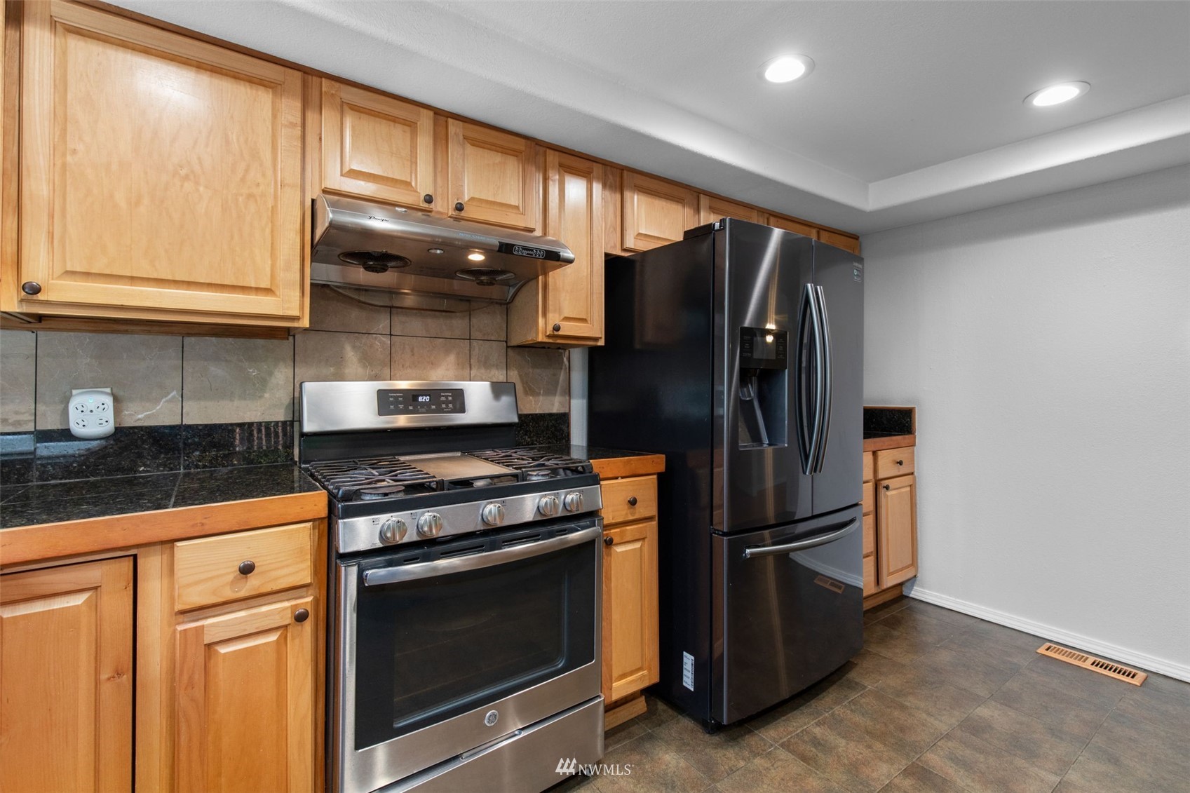 819 Duchess Road Bothell, WA 98012 - Photo 16 of 40 a kitchen with granite countertop a refrigerator stove and microwave