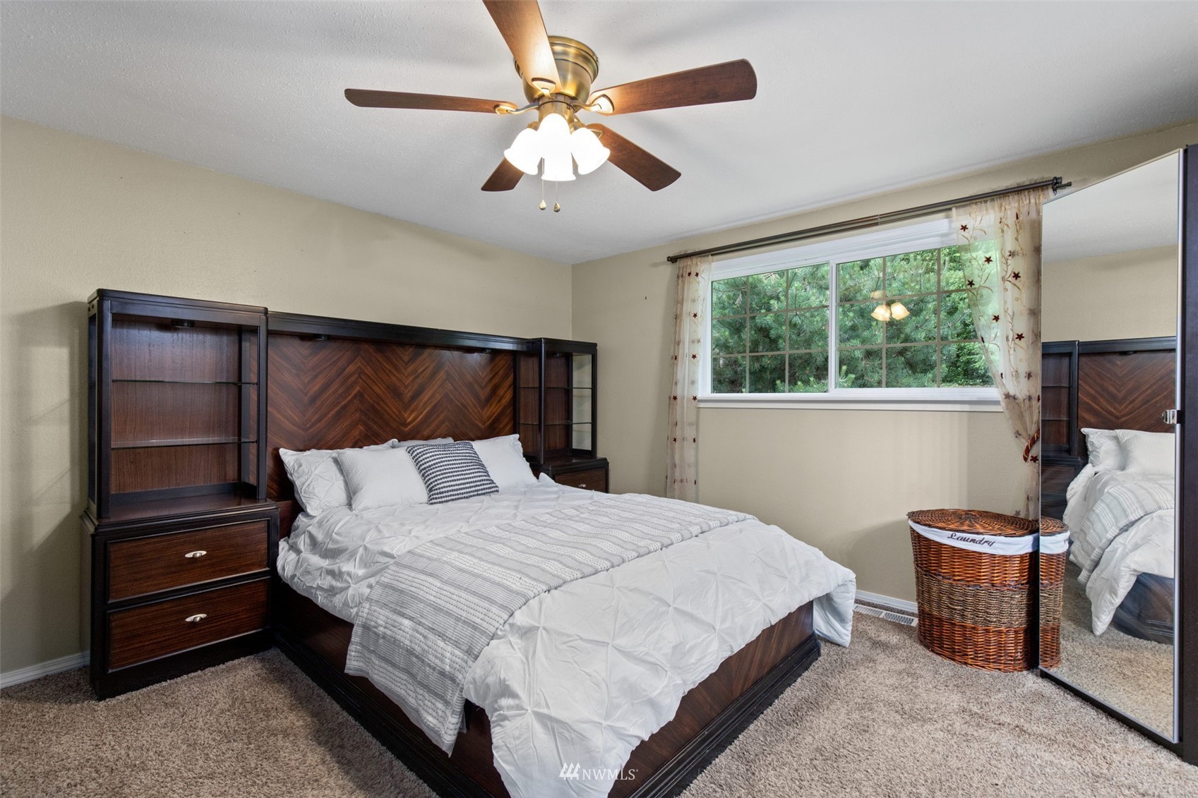 819 Duchess Road Bothell, WA 98012 - Photo 19 of 40 a bedroom with a bed a chandelier and a dresser