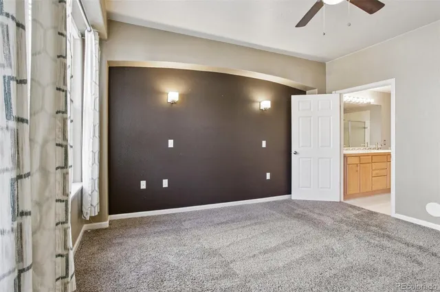 a view of a livingroom with a chandelier fan and windows