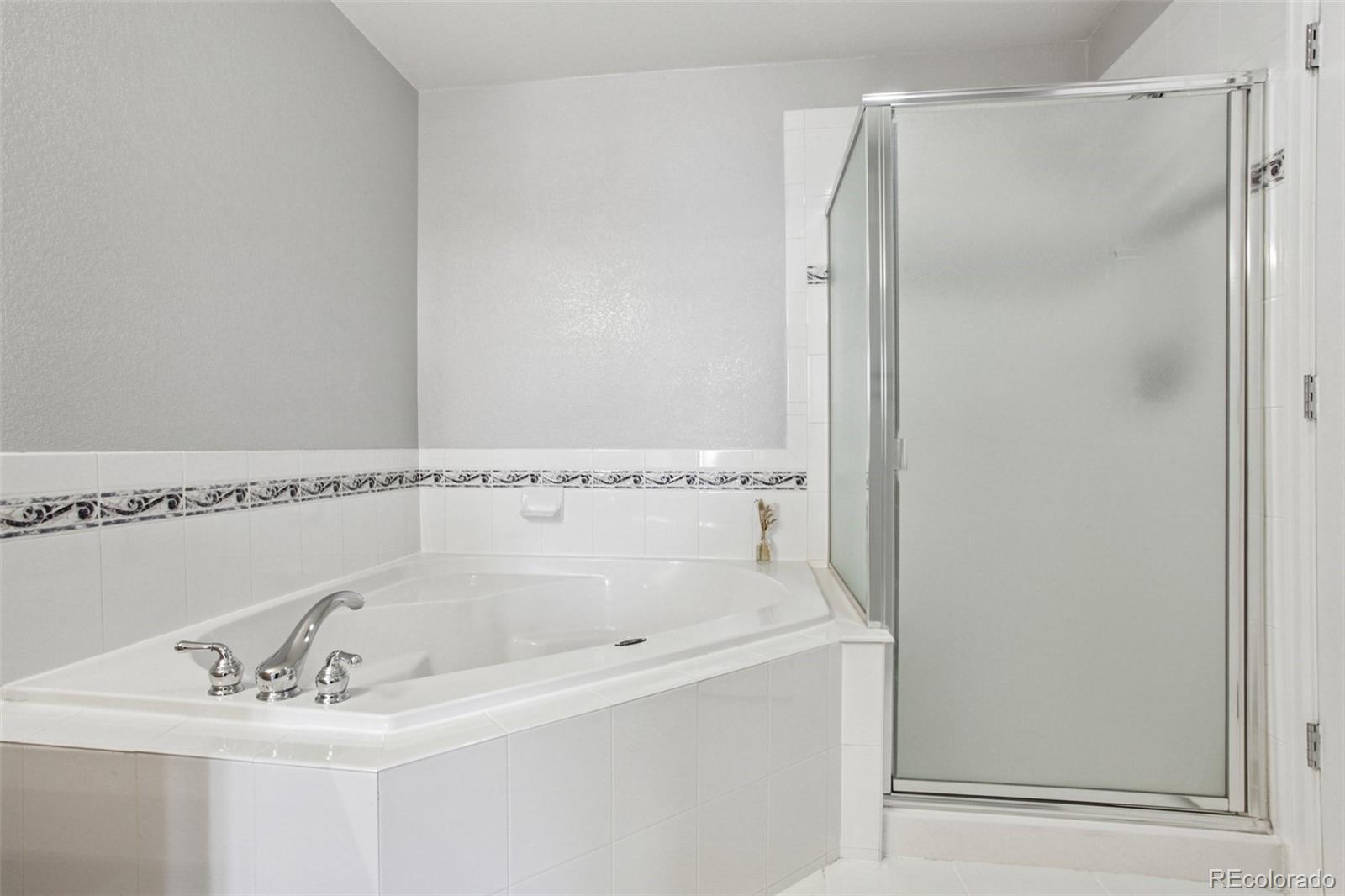 1747 Pearl Street, Unit 106 Denver, CO 80203 - Photo 17 of 26 a bathroom with a bathtub and a shower