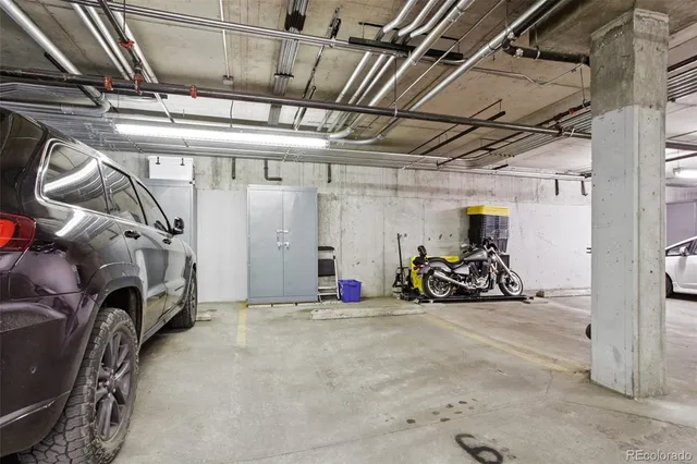 a view of a garage with a bike and white car