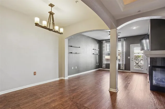 a view of a hallway with wooden floor and a chandelier