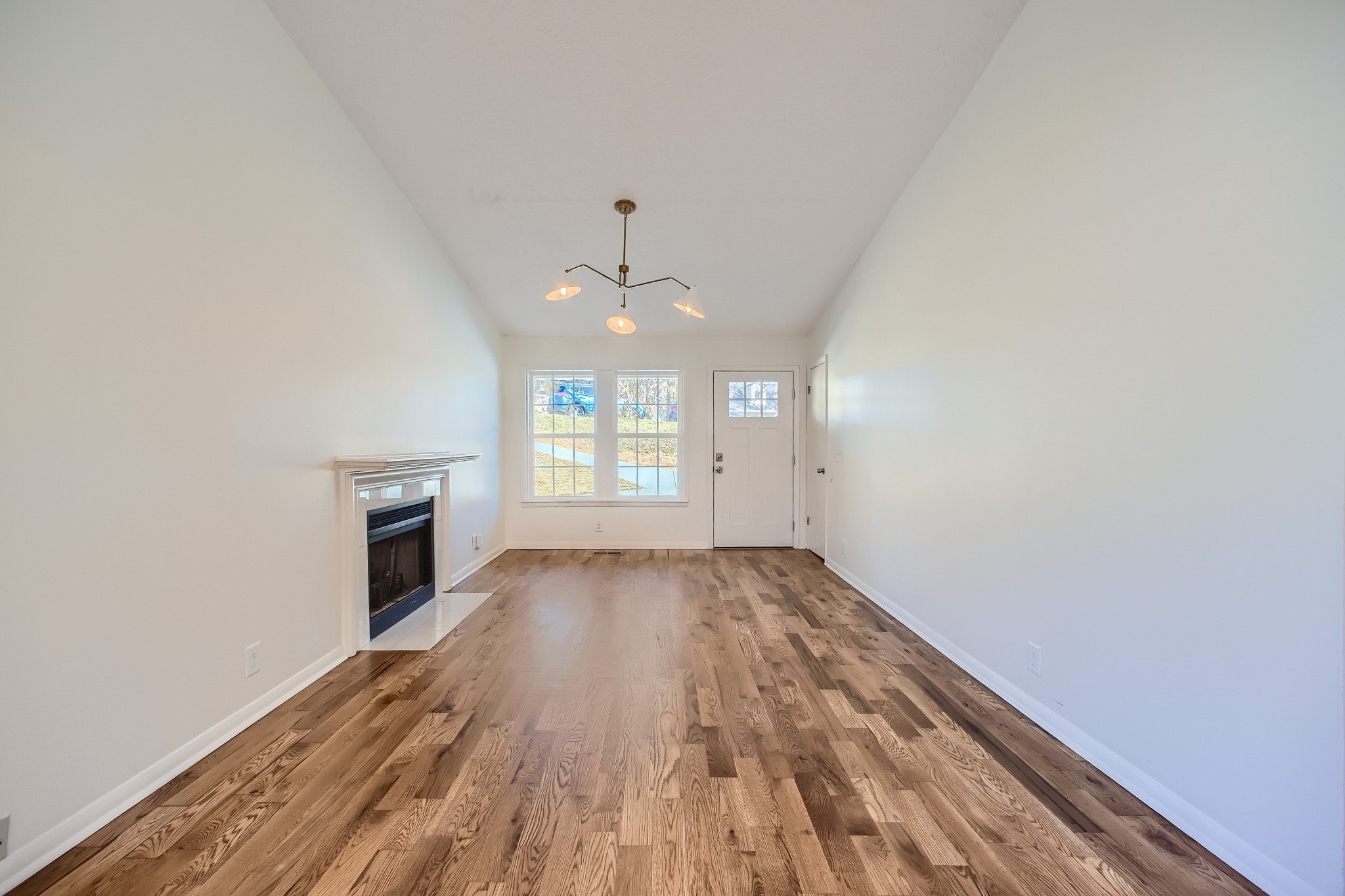 417 Hill Road Nashville, TN 37027 - Photo 6 of 27 an empty room with wooden floor fireplace and windows