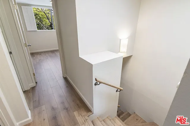a view of a hallway with wooden floor and staircase