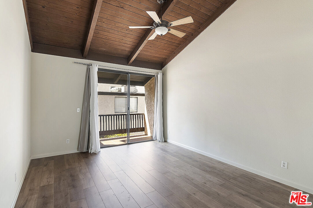 2216 South Bentley Avenue, Unit 10 Los Angeles, CA 90064 - Photo 19 of 40 an empty room with wooden floor and windows