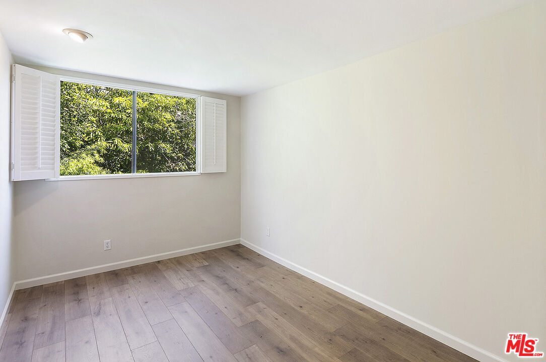 2216 South Bentley Avenue, Unit 10 Los Angeles, CA 90064 - Photo 27 of 40 an empty room with wooden floor and windows