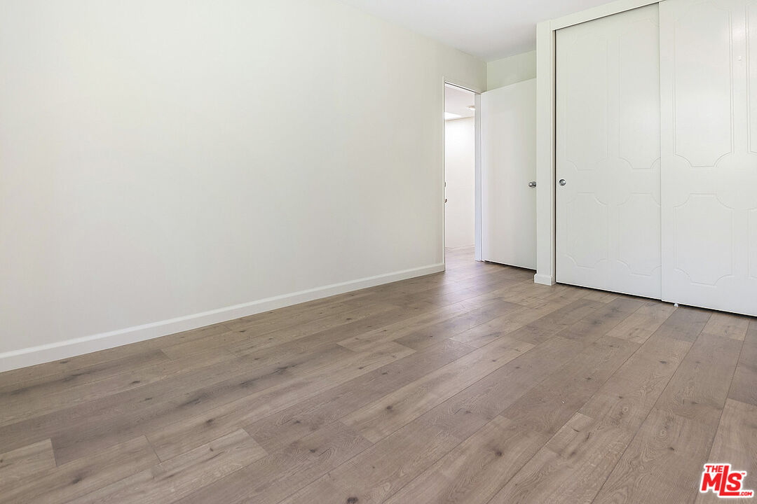 2216 South Bentley Avenue, Unit 10 Los Angeles, CA 90064 - Photo 28 of 40 a view of an empty room with wooden floor and entryway