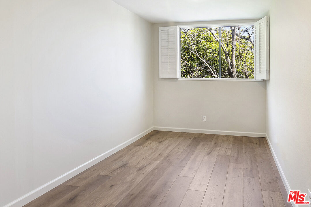 2216 South Bentley Avenue, Unit 10 Los Angeles, CA 90064 - Photo 31 of 40 an empty room with wooden floor and windows