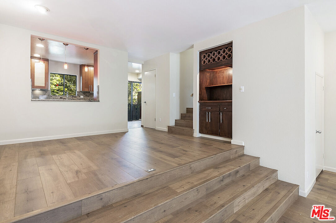 2216 South Bentley Avenue, Unit 10 Los Angeles, CA 90064 - Photo 8 of 40 a view of an empty room with wooden floor and a window