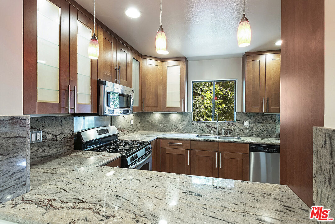 2216 South Bentley Avenue, Unit 10 Los Angeles, CA 90064 - Photo 10 of 40 a kitchen with stainless steel appliances granite countertop a sink and a wooden cabinets