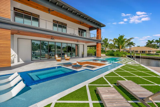 a view of a house with pool and chairs
