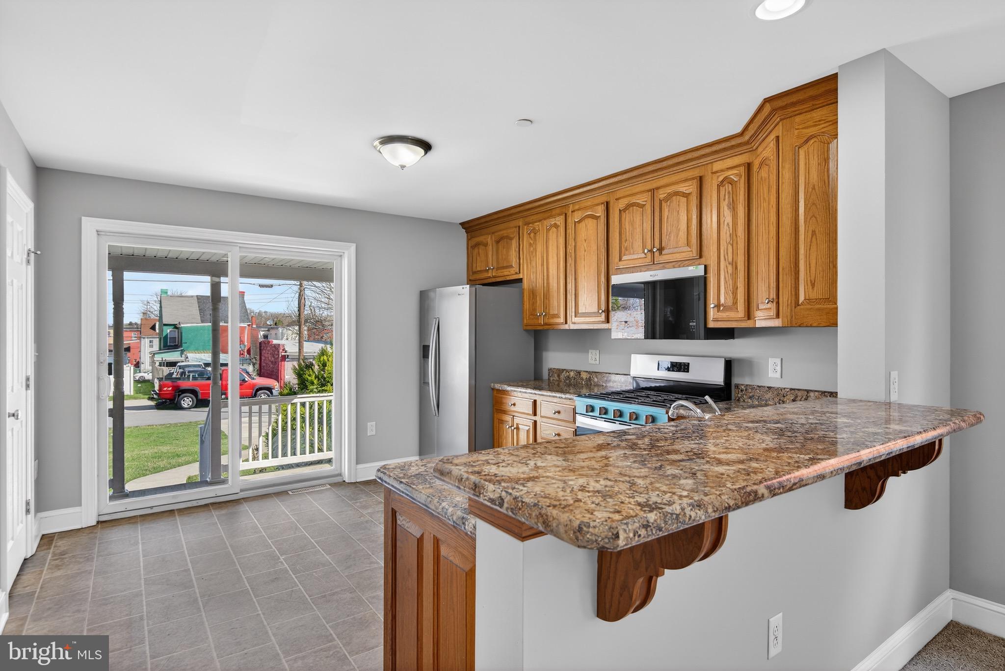 637 East Fulton Street Lancaster, PA 17602 - Photo 7 of 28 a kitchen with stainless steel appliances granite countertop a sink dishwasher stove and refrigerator with wooden floor