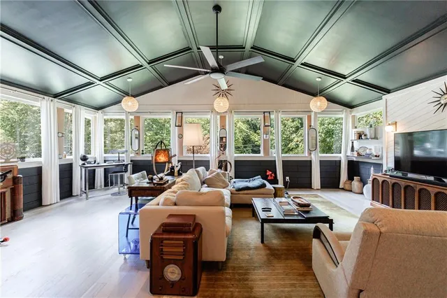 a living room with furniture a flat screen tv and a large window