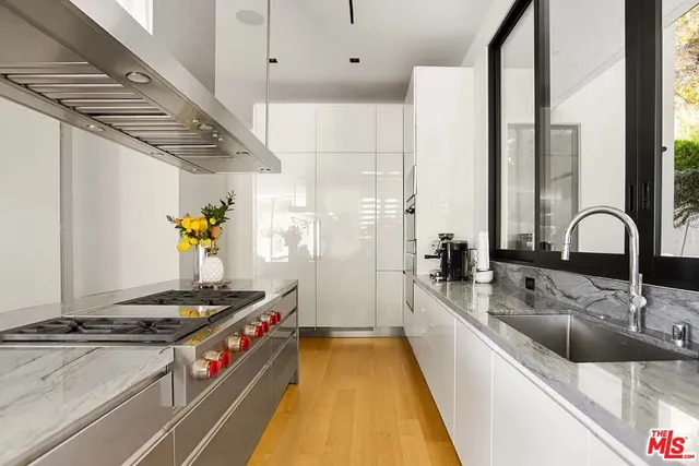 a kitchen with stainless steel appliances a stove and a sink