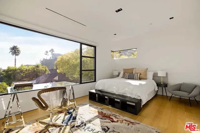 a large bedroom with a bed and large windows