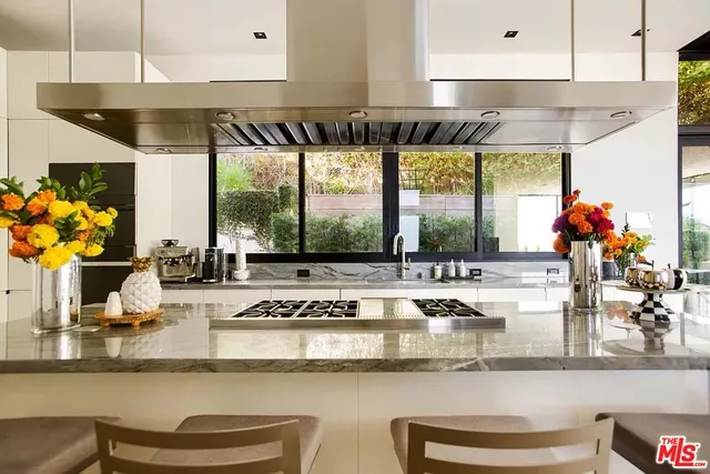 a kitchen with a stove and a white wooden cabinets
