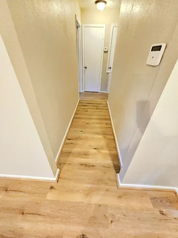 a view of a hallway with wooden floor