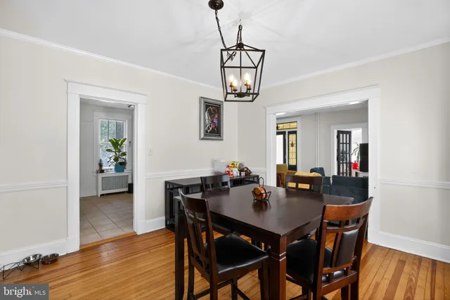 a view of a dining room and livingroom with furniture wooden floor a chandelier