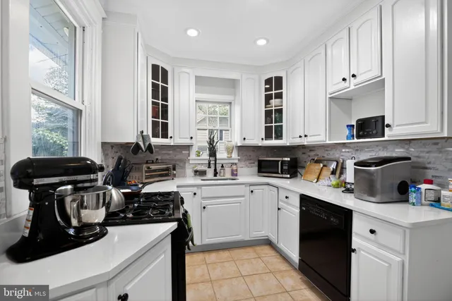 a kitchen with stainless steel appliances granite countertop a stove a sink dishwasher and cabinets with wooden floor