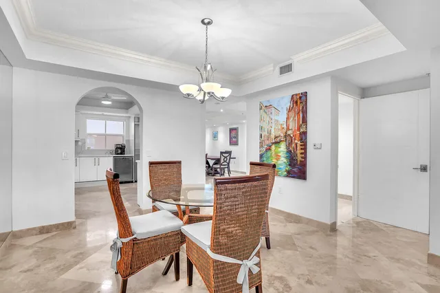 a dining room with furniture a chandelier and window