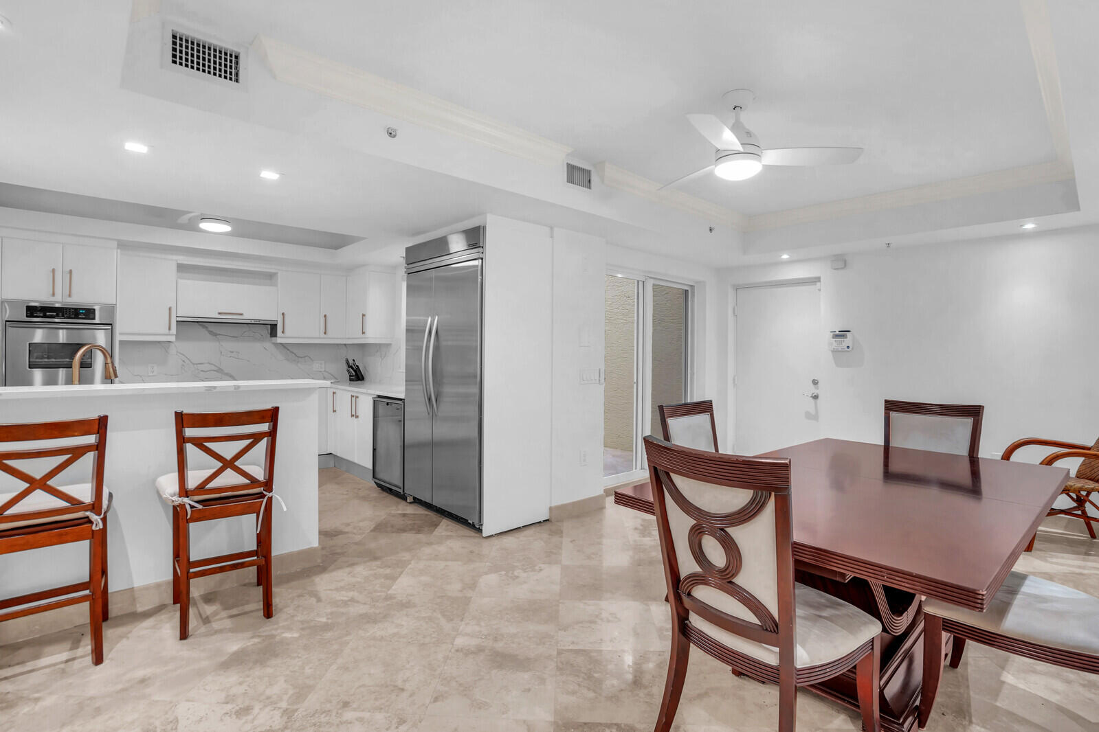 2051 Southeast 3rd Street, Unit TH7 Deerfield Beach, FL 33441 - Photo 21 of 48 a kitchen with stainless steel appliances kitchen island granite countertop a dining table chairs and a refrigerator