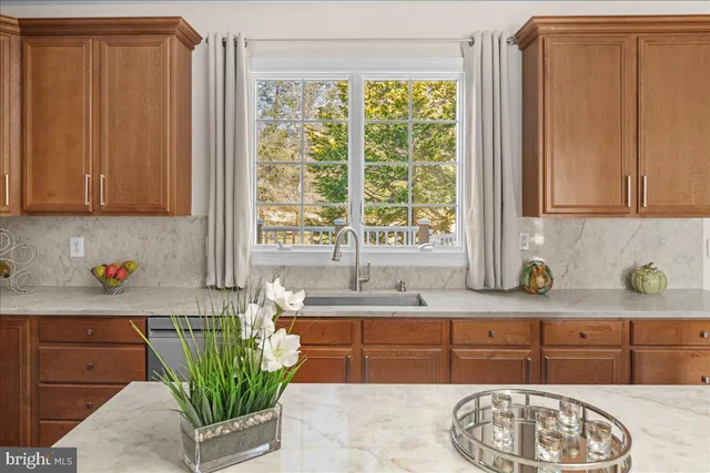 a kitchen with stainless steel appliances white cabinets a sink and a large window