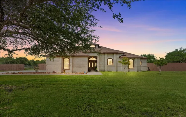a front view of a house with a yard and trees