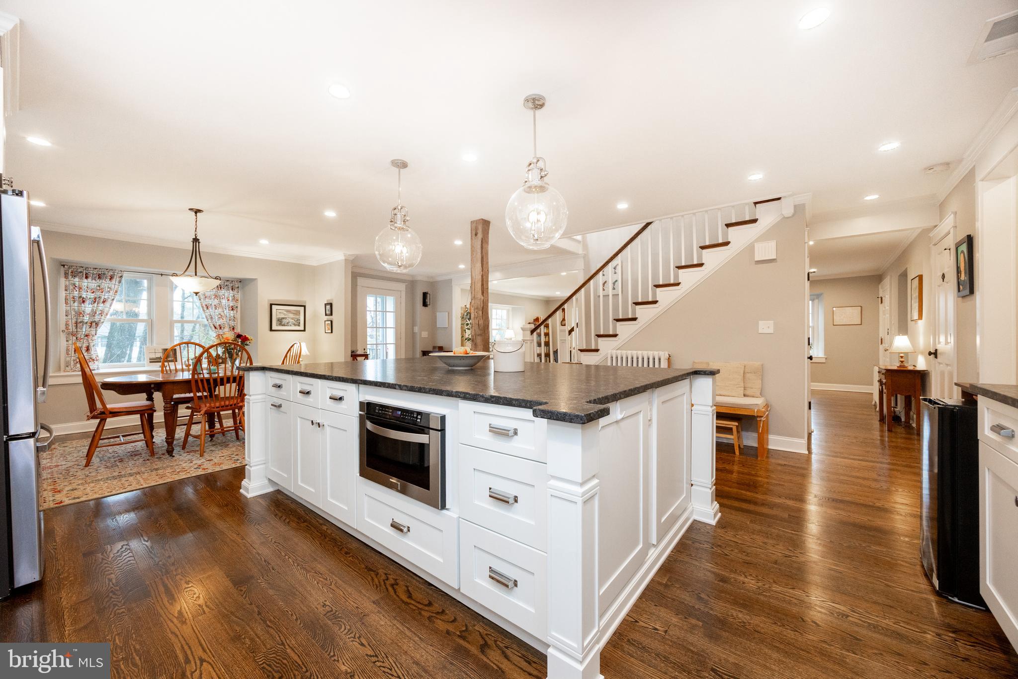 57 Grubb Road Malvern, PA 19355 - Photo 12 of 45 a kitchen with stainless steel appliances kitchen island granite countertop a stove top oven a dining table and chairs with wooden floor