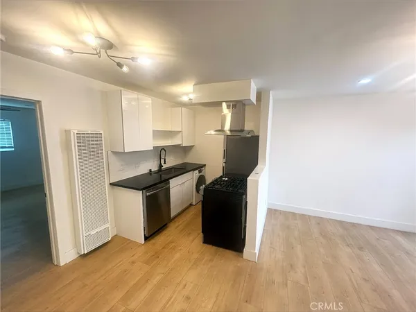 a kitchen with granite countertop a refrigerator and a sink