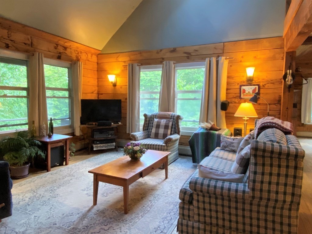 266 Alexander Road Leyden, MA 01337 - Photo 16 of 33 a living room with furniture a flat screen tv and a floor to ceiling window
