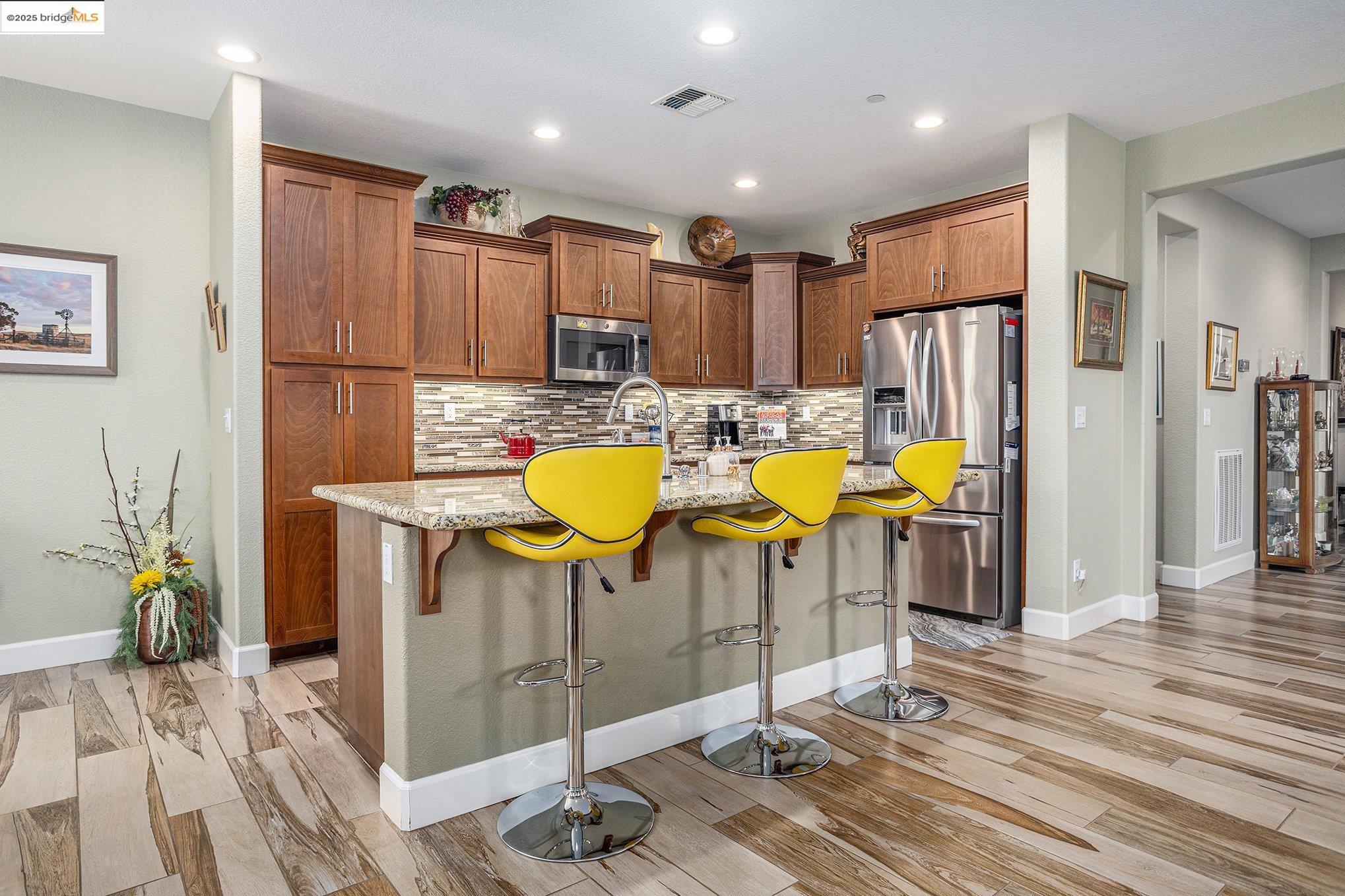 299 Marks Road Rio Vista, CA 94571 - Photo 12 of 39 Kitchen featuring decorative backsplash, light stone countertops, a kitchen breakfast bar, stainless steel appliances, and recessed lighting