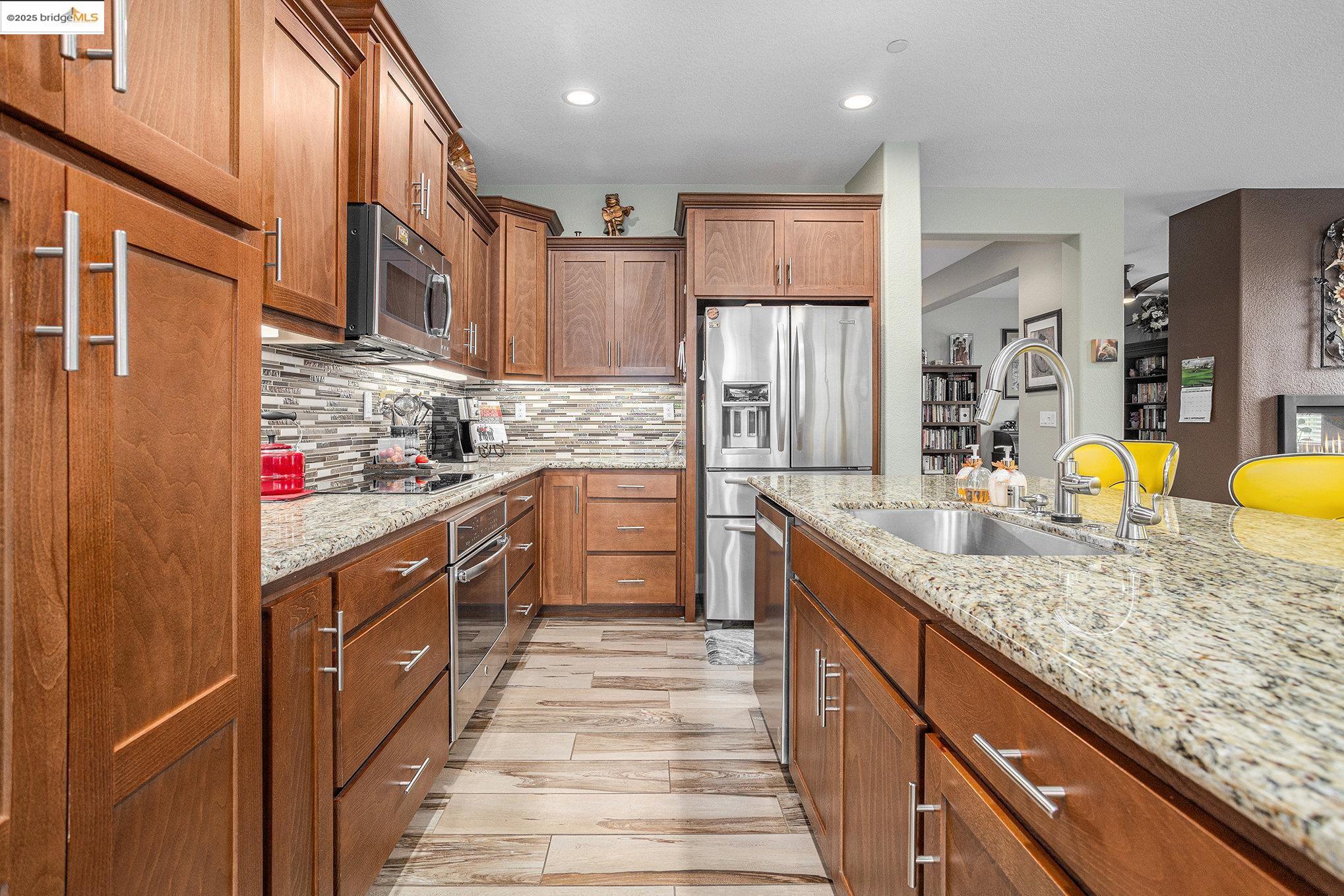 299 Marks Road Rio Vista, CA 94571 - Photo 13 of 39 Kitchen with brown cabinets, decorative backsplash, light stone countertops, appliances with stainless steel finishes, and recessed lighting