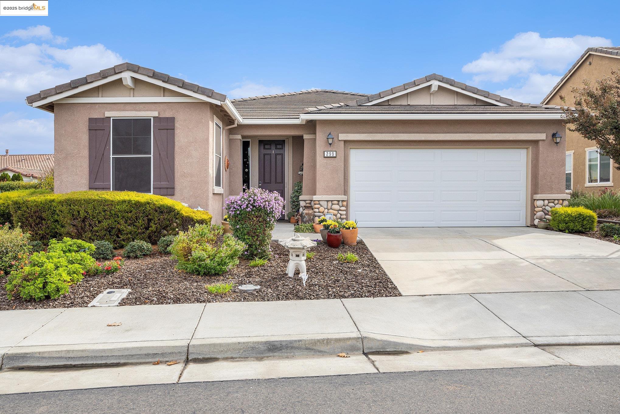 299 Marks Road Rio Vista, CA 94571 - Photo 2 of 39 Ranch-style home with stone siding, stucco siding, concrete driveway, a tiled roof, and a garage