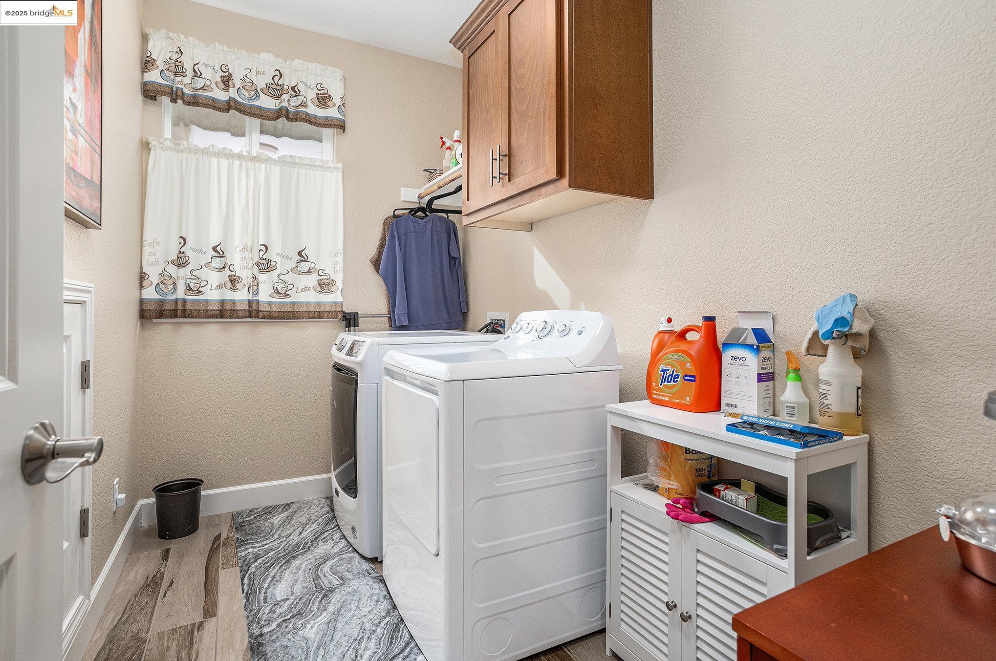 299 Marks Road Rio Vista, CA 94571 - Photo 20 of 39 Laundry room featuring a textured wall, cabinet space, light wood-style flooring, and independent washer and dryer