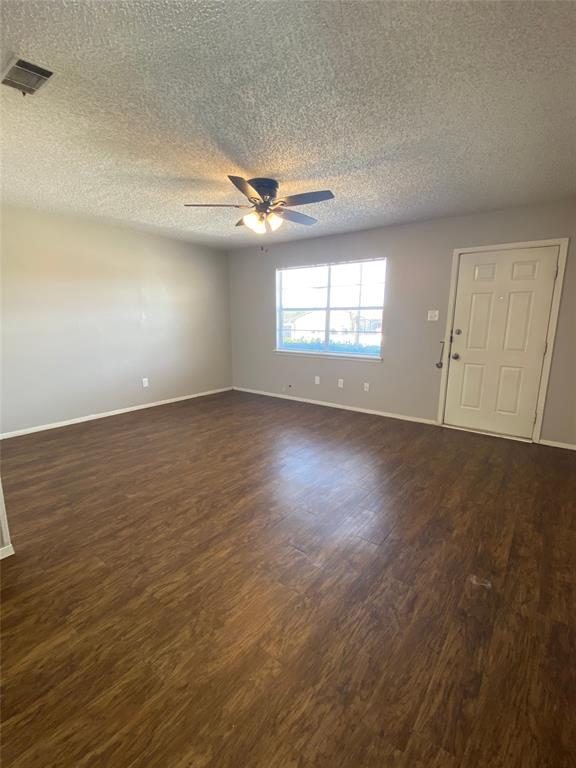 1409 Kilpatrick Court, Unit D Cleburne, TX 76033 - Photo 5 of 10 an empty room with wooden floor ceiling fan and windows