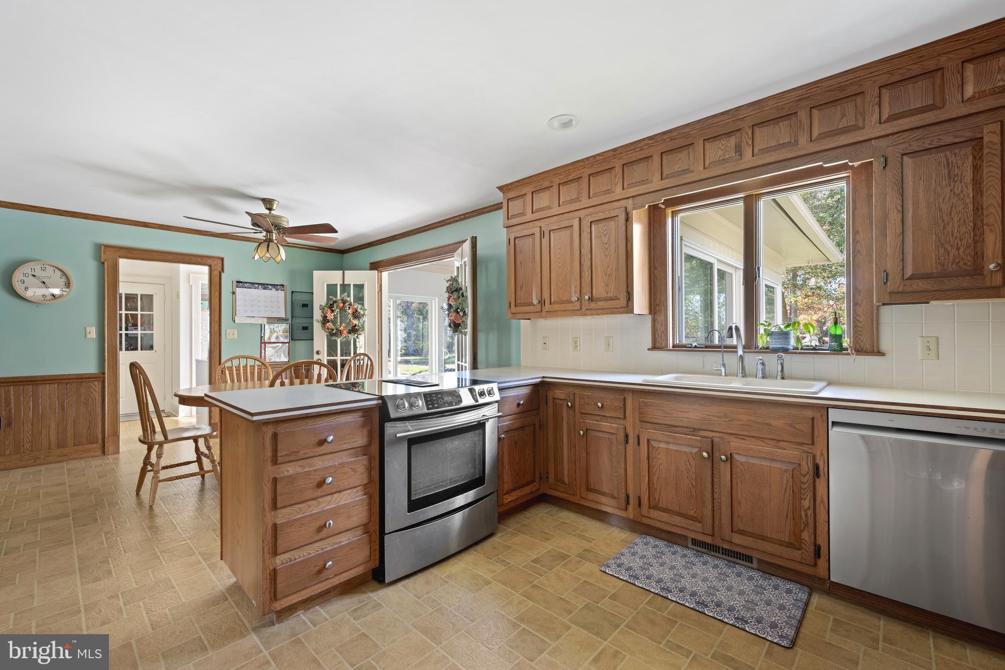 930 Johnson Road Salisbury, MD 21804 - Photo 29 of 69 a kitchen with stainless steel appliances granite countertop a stove top oven a sink dishwasher a dining table and chairs with wooden floor