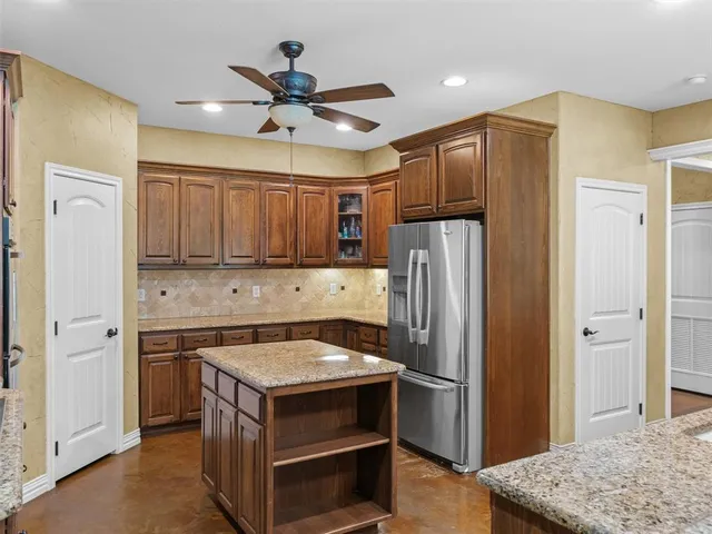 a kitchen with a refrigerator sink and cabinets