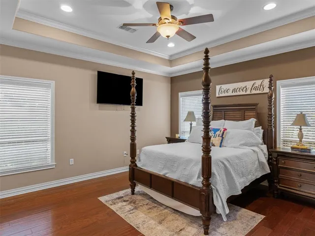 a bedroom with a bed window and a flat screen tv