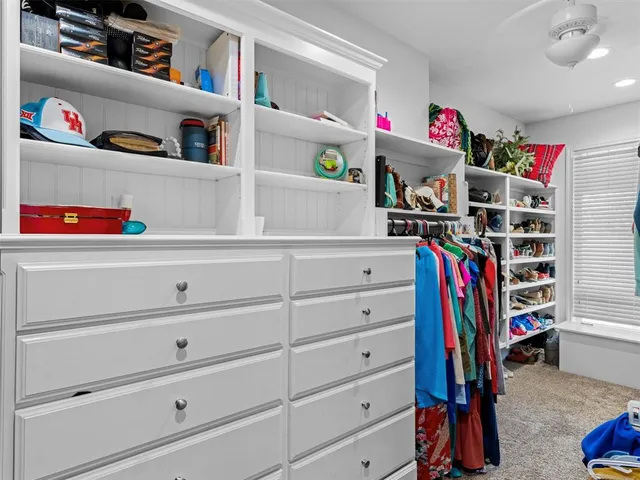 a view of walk in closet with clothes and shoes