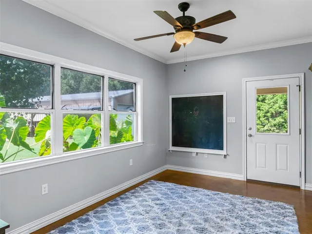 a view of an empty room with window and a ceiling fan