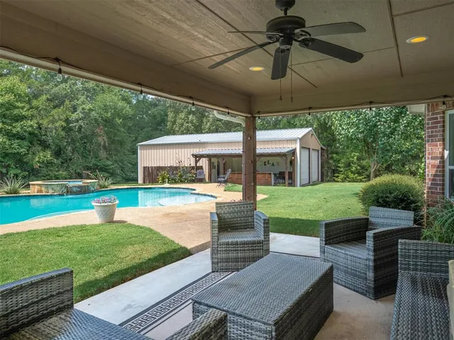 a view of house with backyard swimming pool and furniture