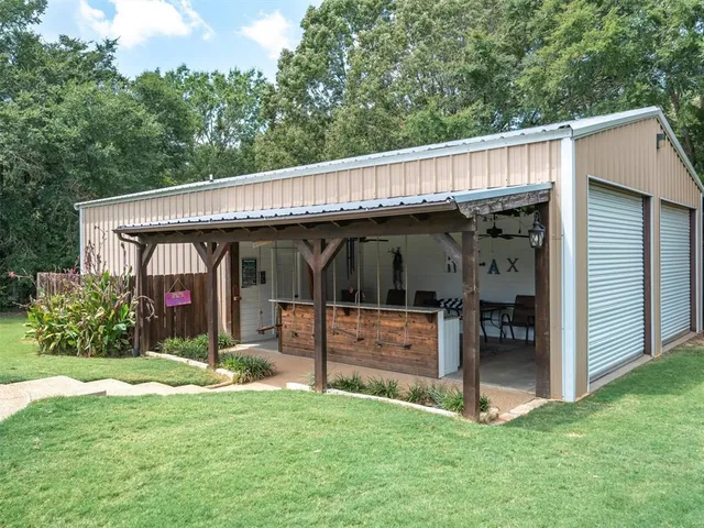 a view of a backyard with a large tree and wooden fence